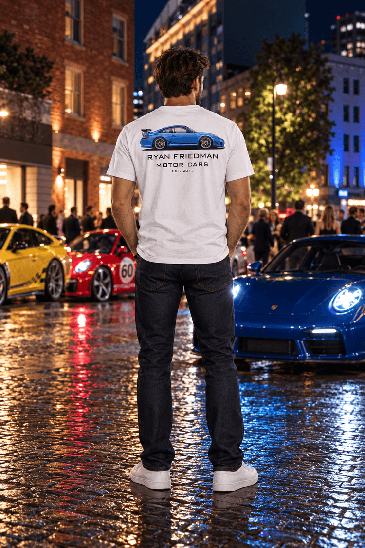 Man wearing the Blue GT3 RS T-Shirt from behind, showing the back print, at a night car meet on a wet cobblestone street